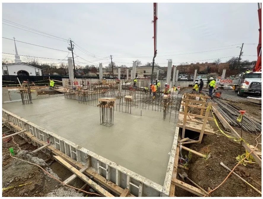 Barry Farm 1A — fresh structural slab placement in progress with crews working around column reinforcing steel.